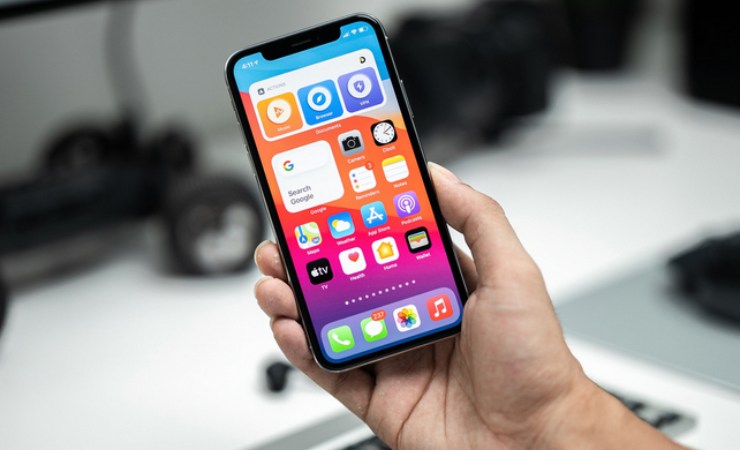 Persona che tiene in mano un iPhone acceso