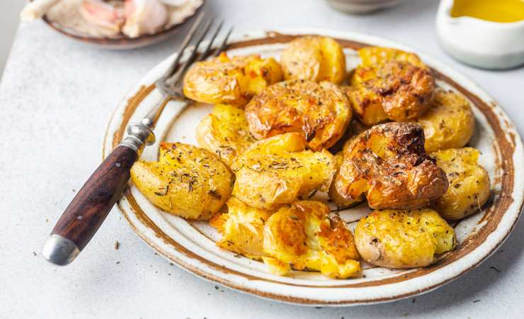 piatto con patate schiacciate al forno