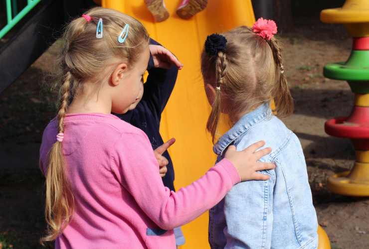 due bambine di spalle al parco