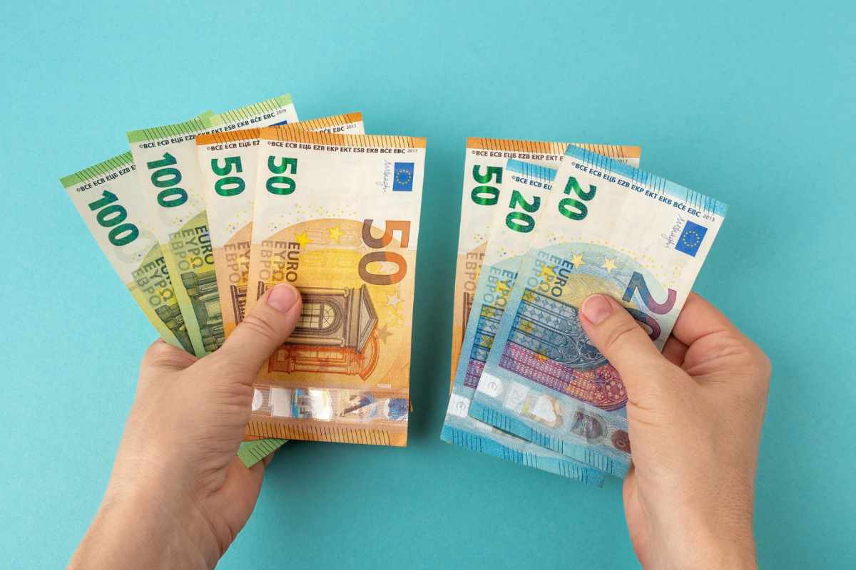 Persona che divide banconote euro
