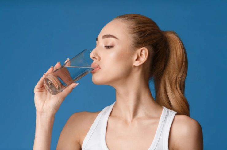 donna che beve un bicchiere di acqua